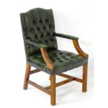 A late 20thC / early 21stC leather Gainsborough chair with deep buttoned brass studded upholstery,