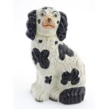 A Victorian Staffordshire seated spaniel with black patch decoration and gilt lock and chain detail.