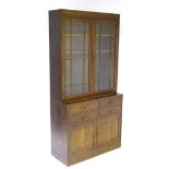 An early 20thC oak glazed bookcase with astragal glazed doors opening to reveal shelves within,