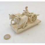 A late 19thC carved Indian ivory figure group depicting two zebu cow / oxen pulling a cart with