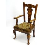 An early 20thC Queen Anne style beech child's chair with floral painted decoration throughout,