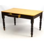 A late 19thC kitchen table with stripped pine top and painted base,