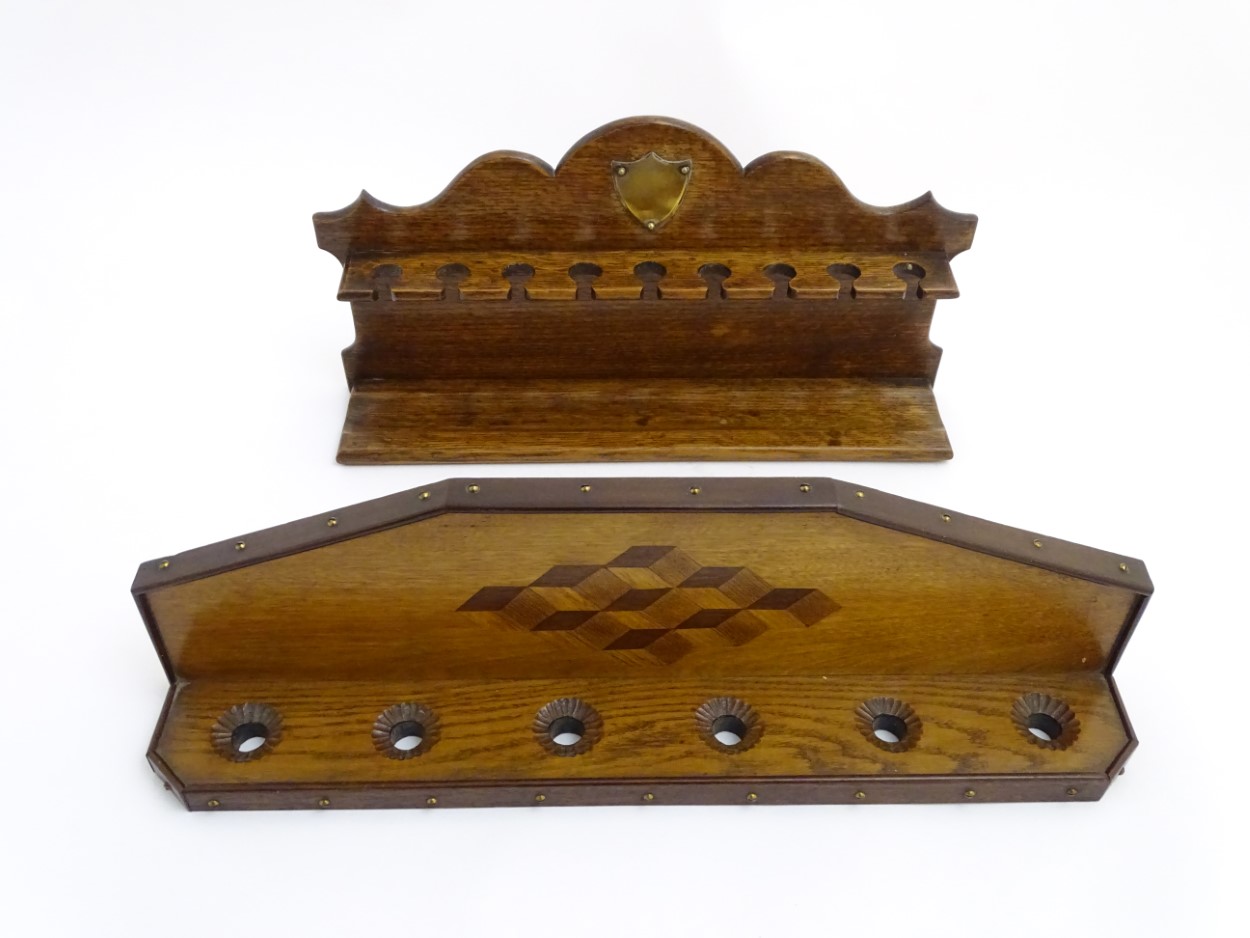 Pipe smoking: An early 20thC oak pipe rack, with provision for nine pipes,