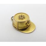 An unusual gold and yellow metal pendant / locket formed as a Continental postman's hat 3/4" long