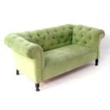 A late 19thC Chesterfield sofa with deep buttoned upholstery and drop end,