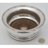 A late 19thC / early 20thC silver plate coaster with turned wooden base 6" diameter