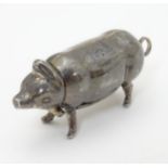 A novelty white metal small vesta case formed as a pig with hinged head and striker under.