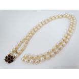 A single strand pearl necklace with 9ct gold clasp set with 7 garnets approx 32" long