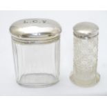 A cut glass dressing table jar with silver top hallmarked London 1917 and another hallmarked London