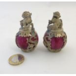 A pair of unusual white metal Dogs of Fo mounted upon a spherical red marbled sphere 2 3/4" high