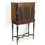 A mid 19thC rosewood collectors cabinet with three glazed doors flanked by turned reeded baluster