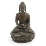 A cast bronze Buddha sat cross legged on a lotus flower base.