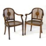 A pair of early 20thC open armchairs with caned seats and backrest, curved top rail,
