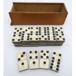 A set of half bone, half ebony dominoes, in a sliding wooden box,