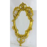 A late 19thC gilt mirror of oval form with carved floral decoration,