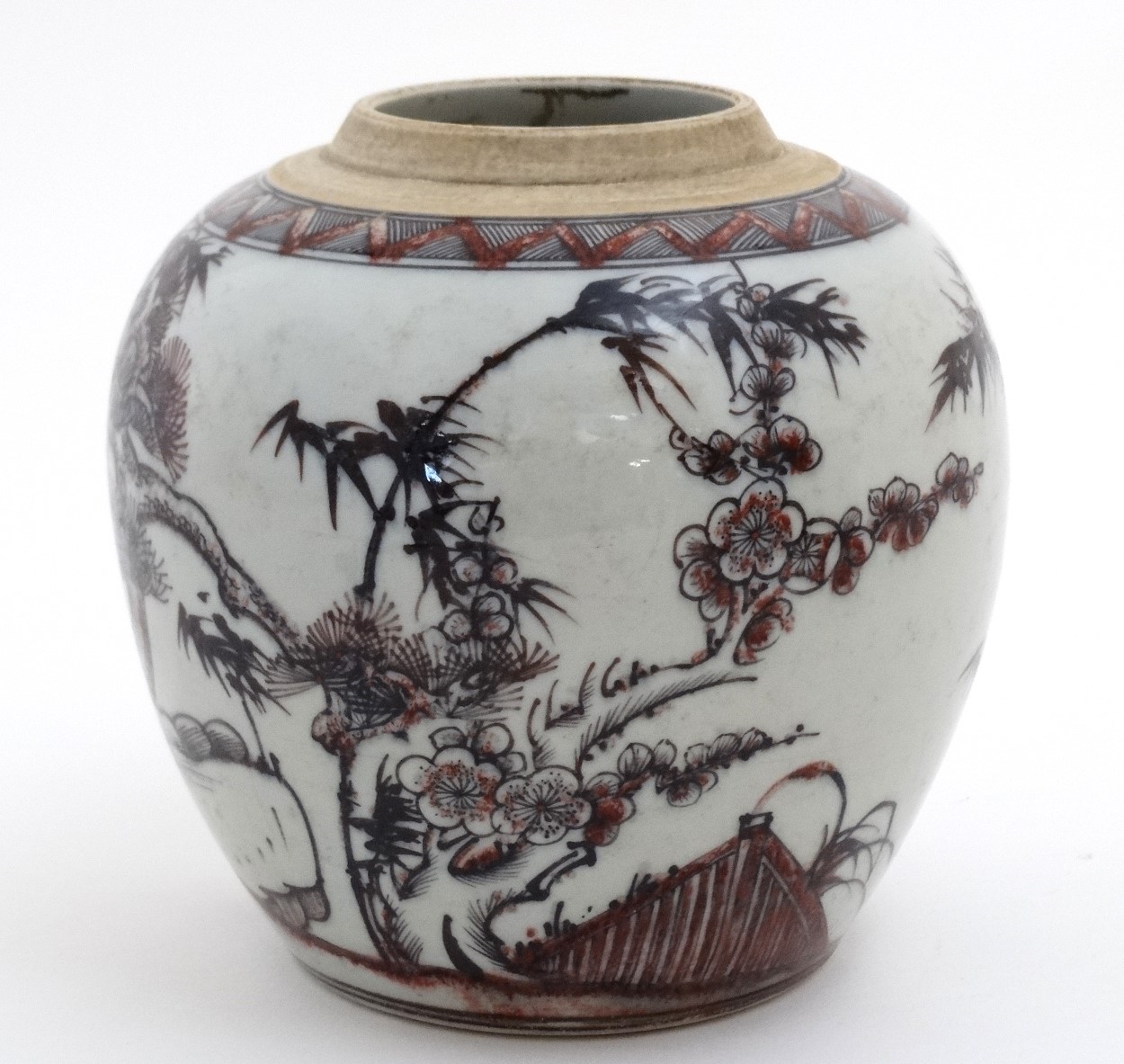 A Chinese red, black and white vase decorated with cherry blossom and bamboo on a rocky outcrop,