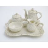 An Art Nouveau bisque part tea set with floral decoration in high relief, to include a teapot,