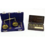 A Bakelite cased set of scales together with a cased set of brass balance scales.