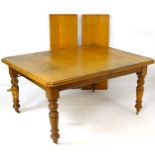 An early 20thC oak extending dining table with rectangular moulded top,