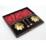 A pair of silver plat salts and salt spoons. Cased.