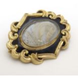 Memorial / Mourning jewellery : A 19thC yellow metal and black enamel brooch with lock of hair to