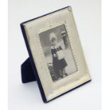 An easel back photograph frame with silver surround.
