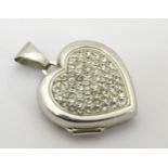 A silver heart shaped locket set with white stones.
