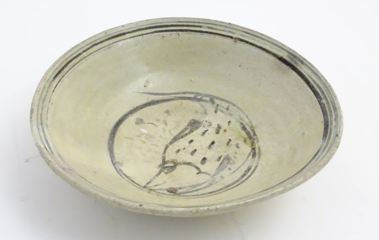 A Chinese Ming Dynasty celadon glazed bowl with hand painted fish decoration to the centre and