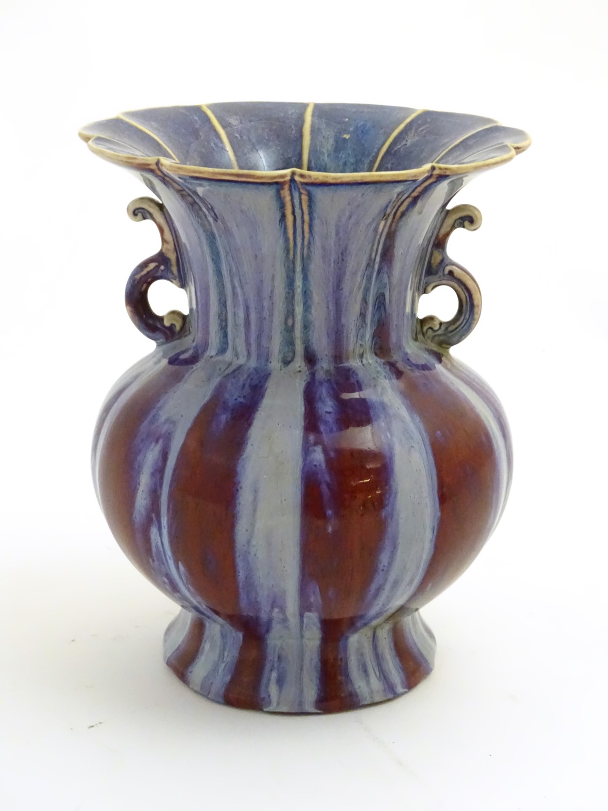 A twin handled Chinese high-fired, flambe globular vase with a splayed foot and flared rim.