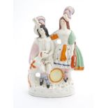 A Staffordshire pottery figural group of two figures with instruments in formal wear and plumed
