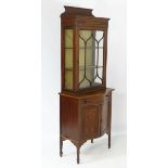 An early 20thC mahogany cabinet, both the top and the base having marquetry detailing,