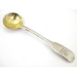A Victorian silver fiddle pattern salt spoon with gilded bowl and engraved armorial to handle.