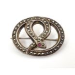 A silver brooch of snake form set with marcasite and garnet detail.