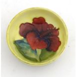 A small footed Moorcroft bowl with hibiscus decoration. Height approx. 1 1/2", diameter approx.