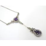 A silver necklace set with amethyst, peridot and seed pearls.