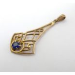 A vintage 10k gold pendant set with blue tourmaline like stone. 1 1/4" long.