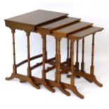 A nest of four early 20thC Regency style mahogany tables, having crossbanded tops,