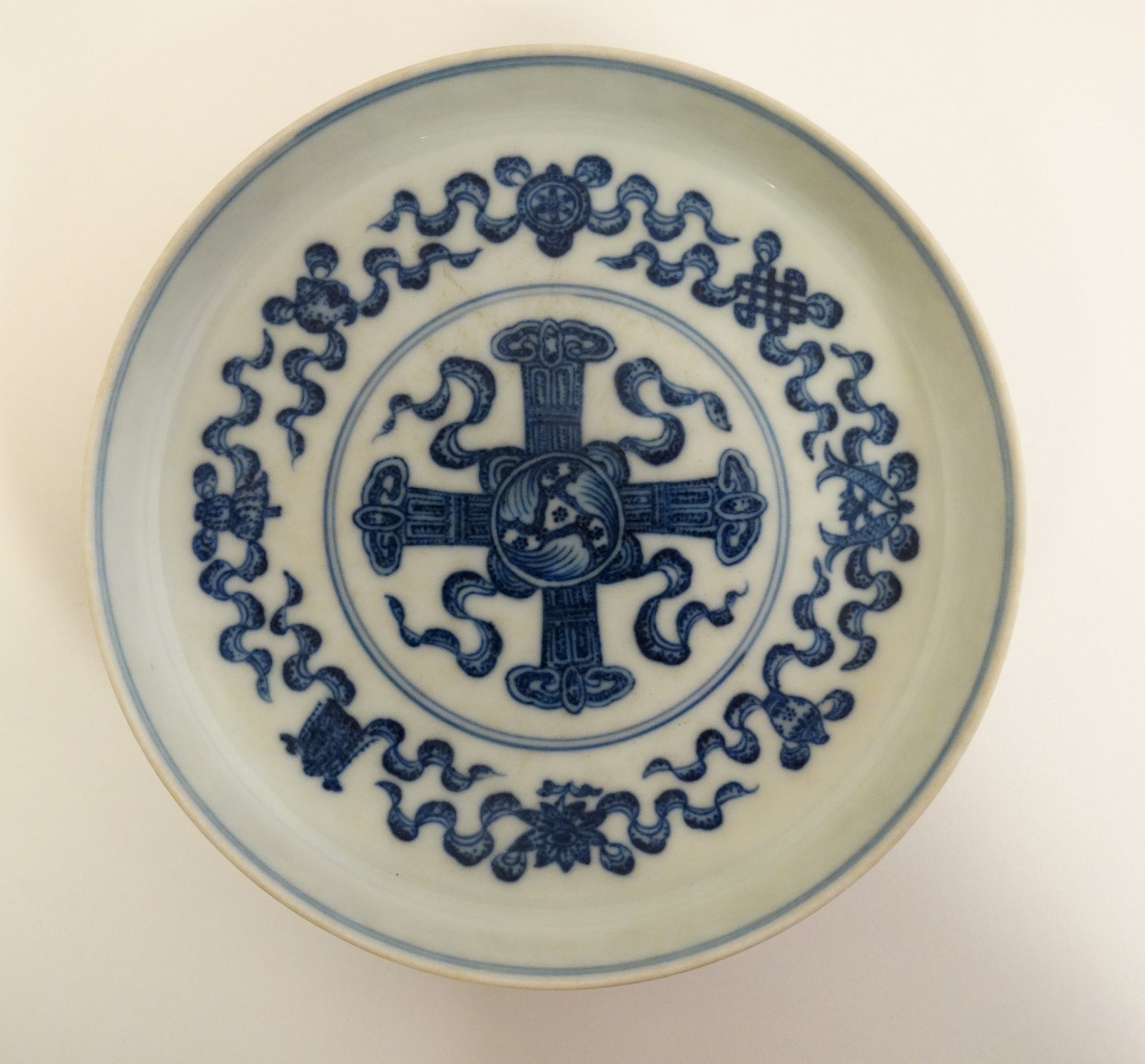A Chinese blue and white dish on small pedestal base, decorated with the symbols of the 8 immortals,