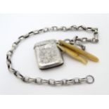 A white metal chain with bone charms and a silver vesta case hallmarked Birmingham 1895.