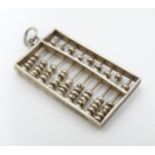 A white metal novelty pendant formed as an abacus with moving beads.