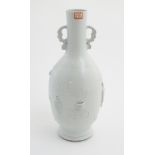 A white celadon bottle vase with relief decoration of flowers in vases and Chinese characters,