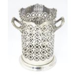 A silver plate soda siphon stand with twin handles and frett work decoration.