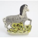 A flat back Staffordshire circus pony painted as a zebra with gilt highlights. Approx.