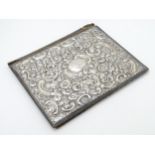 A Victorian silver fronted desk blotter of book form having profuse embossed C Scroll and floral