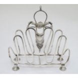 A silver plate toast / letter rack with scroll and shell decoration 7" high x 6 3/4" long