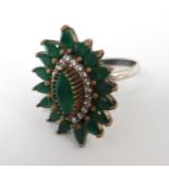 A silver dress ring in the Indian style, set with green and white stones.