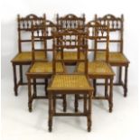 A set of six oak dining chairs with carved cresting rail and spindled backrest with turned uprights