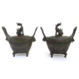 A pair of Chinese boat shaped 4 - legged censors surmounted by mythical beasts and having patterned