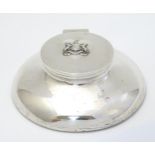 A silver inkwell of capstan form with coat of arms to the hinged lid.