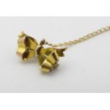 A 9ct gold bow brooch / safety chain. The bow 5/8" wide.